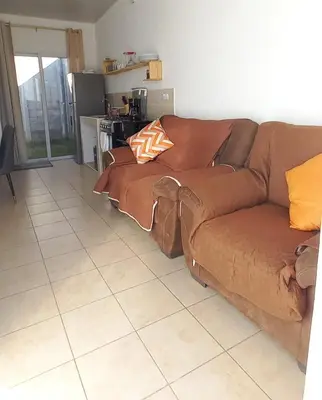 a brown couch sitting in a living room at Santa Ana Maquilishuat in Santa Ana