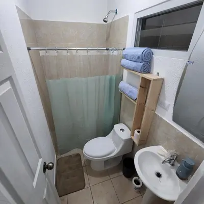 a small bathroom with a toilet and a sink at Santa Ana Maquilishuat in Santa Ana