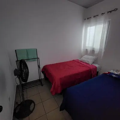 a room with two beds and a fan in it at Santa Ana Maquilishuat in Santa Ana
