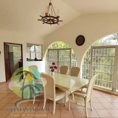 a dining room with a white table and chairs at Quinta Sandoval Lago de Coatepeque in Santa Ana