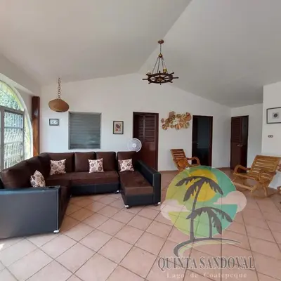 a living room with a couch and a table at Quinta Sandoval Lago de Coatepeque in Santa Ana
