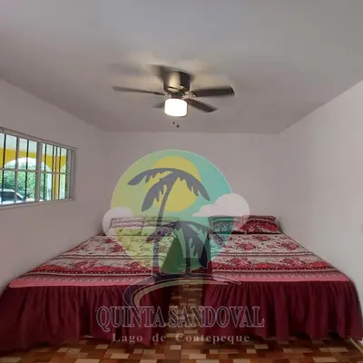 a bedroom with a bed with a glass table at Quinta Sandoval Lago de Coatepeque in Santa Ana