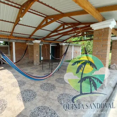 an outdoor patio with a hammock in a pavilion at Quinta Sandoval Lago de Coatepeque in Santa Ana