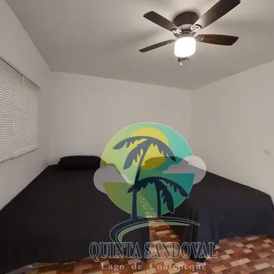 a bedroom with a bed with a ceiling fan at Quinta Sandoval Lago de Coatepeque in Santa Ana