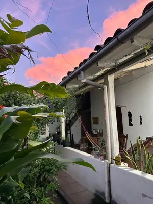 a balcony of a house with a pink at Hostal El Amate #3 in Suchitoto