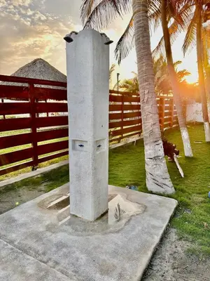 a concrete pillar next to a fence and palm trees at Rancho El Angel, La Costa Del Sol in San Luis La Herradura