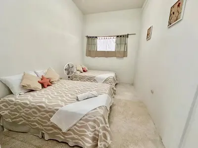 a bedroom with two beds and a window at Rancho El Angel, La Costa Del Sol in San Luis La Herradura