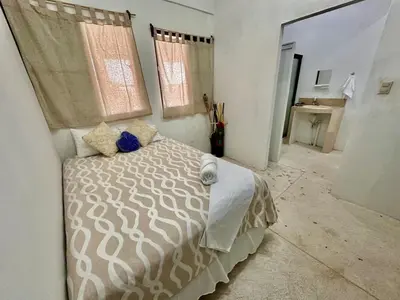 a bedroom with a bed and two windows at Rancho El Angel, La Costa Del Sol in San Luis La Herradura