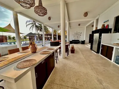 a kitchen with a counter with chairs and a counter top at Rancho El Angel, La Costa Del Sol in San Luis La Herradura