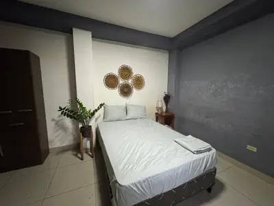a bedroom with a bed with white sheets at Macaw Stay Room in Sonzacate