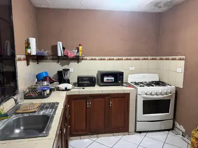 a kitchen with a stove and a sink at Macaw Stay Room in Sonzacate