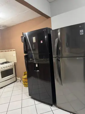 a black refrigerator in a kitchen next to a stove at Macaw Stay Room in Sonzacate