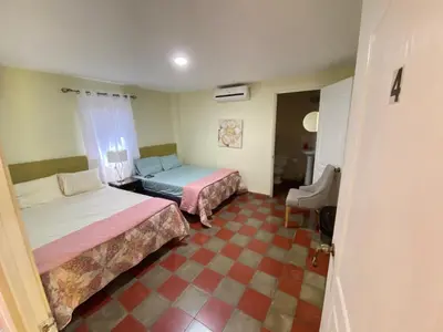 a hotel room with two beds and a couch at Hotel y Restaurante Ocean Corner in El Zonte