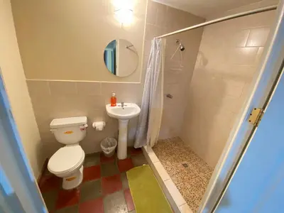 a bathroom with a toilet and a sink at Hotel y Restaurante Ocean Corner in El Zonte