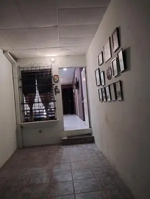 a hallway with a mirror and pictures on the wall at Casa Dorada in Santa Ana