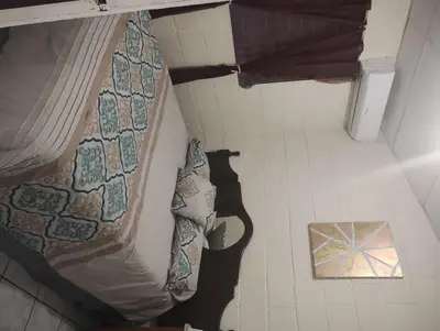 a bed in a small room with a floor at Casa Dorada in Santa Ana