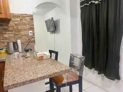 a kitchen with a counter and a table with chairs at Hostal Maracay San Salvador in San Salvador