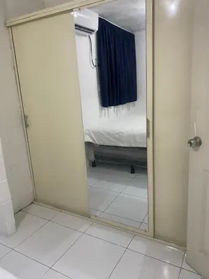 a mirror in a room with a bedroom and a bed at Hostal Maracay San Salvador in San Salvador