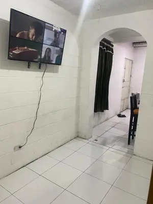 a room with a tv on a wall with a tile floor at Hostal Maracay San Salvador in San Salvador