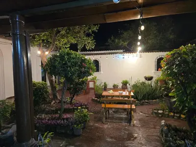 a garden at night with a wooden table and bench at Antique Luna in Santa Ana