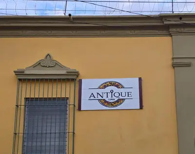 a sign on the side of a yellow building at Antique Luna in Santa Ana