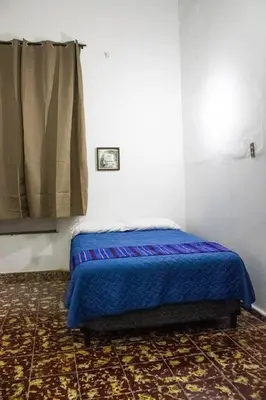a bedroom with a bed with a blue blanket at Antique Luna in Santa Ana