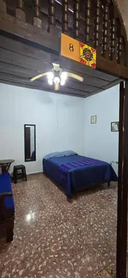 a bedroom with a blue bed and a ceiling fan at Antique Luna in Santa Ana
