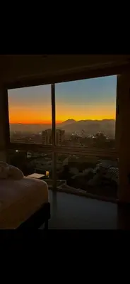 a bedroom with a large window looking out at the sunset at The Sky View in San Salvador