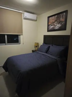 a bedroom with a bed with a blue comforter at The Sky View in San Salvador