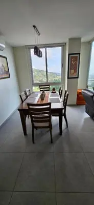 a dining room with a table and chairs and a large window at The Sky View in San Salvador