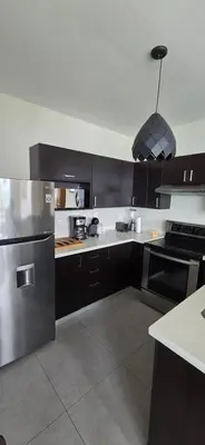 a kitchen with black cabinets and a stainless steel refrigerator at The Sky View in San Salvador