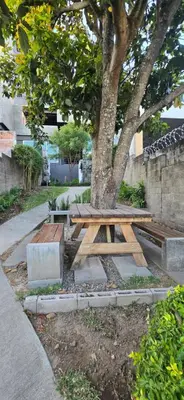 a picnic table under a tree next to a sidewalk at The Sky View in San Salvador