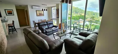 a living room with couches and a large window at The Sky View in San Salvador