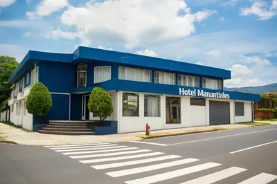 a blue building with a hotel manufacturer sign on it at Hotel Manantiales El Salvador in San Salvador