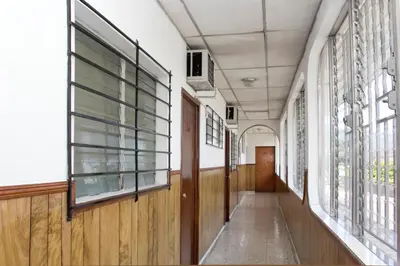 an empty hallway in a school building with windows at Hotel Manantiales El Salvador in San Salvador