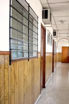 an empty hallway in an old building with a window at Hotel Manantiales El Salvador in San Salvador