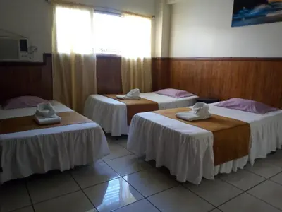 a room with three beds with towels on them at Hotel Manantiales El Salvador in San Salvador