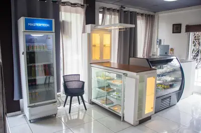 a kitchen with a refrigerator and a chair in it at Hotel Manantiales El Salvador in San Salvador