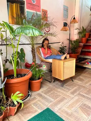 a woman sitting in a chair talking on a cell phone at Karma Muse Hotel in La Libertad