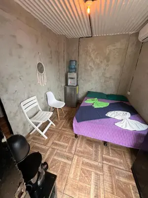 a bedroom with a bed and a chair in it at Karma Muse Hotel in La Libertad