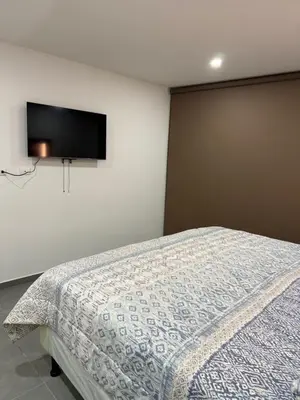 a bedroom with a bed with a tv on the wall at Paradise Apartment at Gallerias Escalon in Colonia Escalón