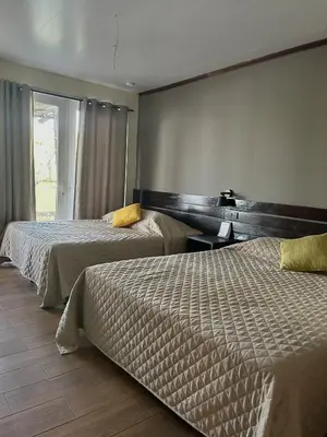 a hotel room with two beds and a window at Estero View Beach House in Barra de Santiago