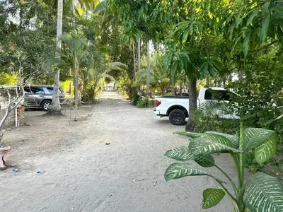 a white truck parked on a dirt road with trees at Estero View Beach House in Barra de Santiago