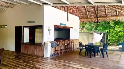a patio with a table and chairs and a television at Estero View Beach House in Barra de Santiago