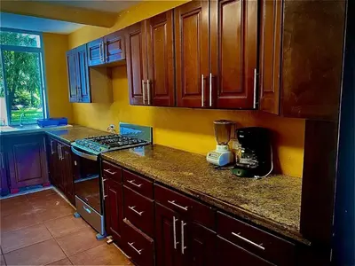 a kitchen with wooden cabinets and a blender on the counter at Estero View Beach House in Barra de Santiago