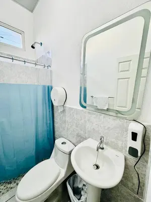 a bathroom with a toilet and a sink and a mirror at Casa Monaco in San Miguel