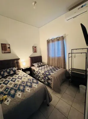 a bedroom with two beds and a window at Casa Monaco in San Miguel
