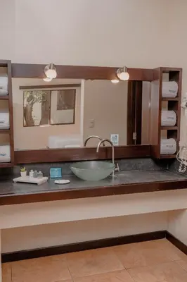 a bathroom counter with a sink and a mirror at Boca Olas Resort Villas in La Libertad