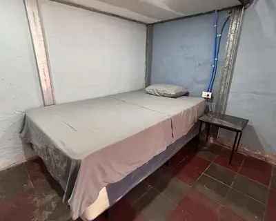 a small bed in a room with a side table at La Casita de Nataly in Santa Ana