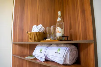 a shelf with a bottle of wine and a towel at Eco Suites El Zonte in La Libertad
